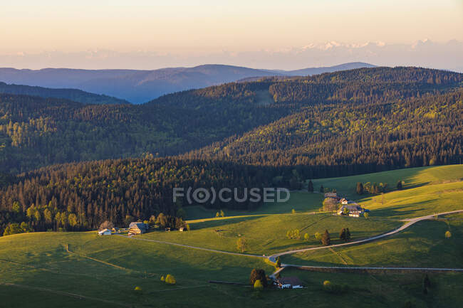 Німеччина, Баден-Вуртемберг, Гофсрунд, гірське село на світанку з лісом на задньому плані — стокове фото