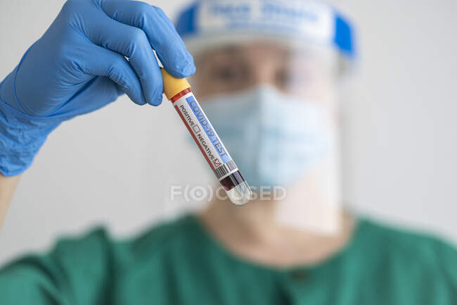 Woman in protective wear holding negative covid-19 test — Stock Photo