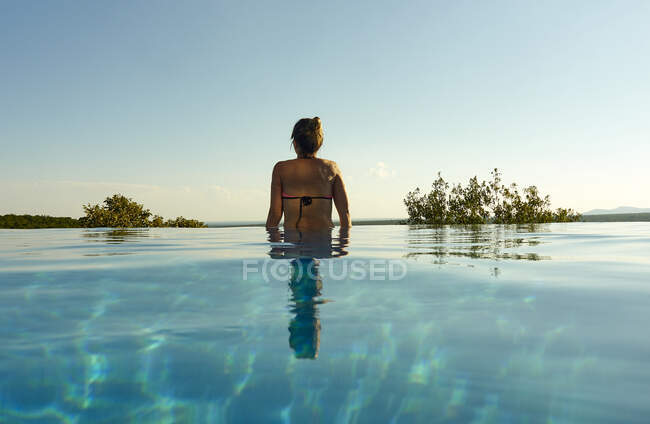 Vista posteriore della donna in piedi in piscina a sfioro — Foto stock