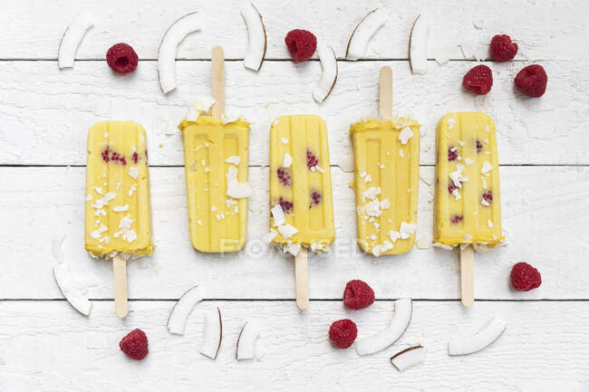Homemade mango and raspberry popsicles with coconut chips — Stock Photo