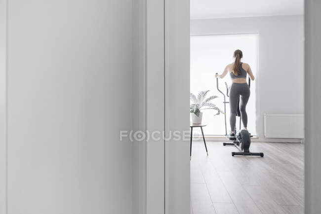 Frau beim Training auf Crosstrainer zu Hause — Stockfoto