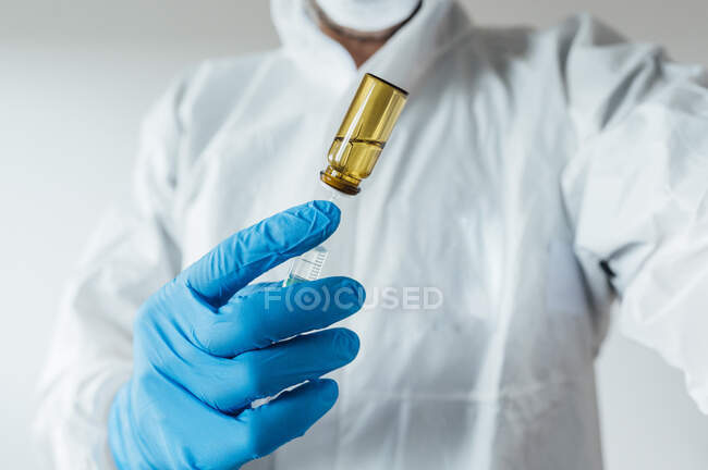 Technicien de laboratoire portant des vêtements de protection, tenant le vaccin — Photo de stock