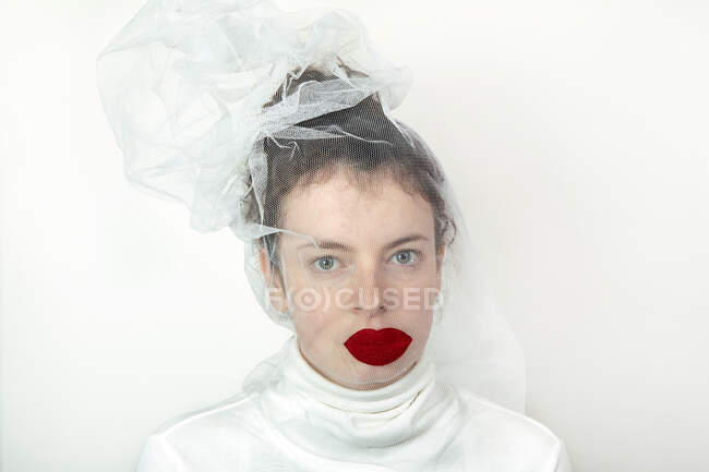 Porträt einer jungen Frau mit transparenter Tüllmaske und roten Fake-Lippen — Stockfoto