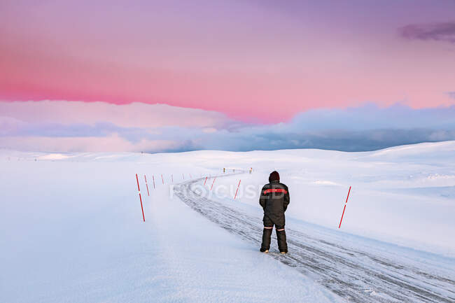 Homem de pé na estrada em paisagem de inverno, Tana, Noruega — Fotografia de Stock