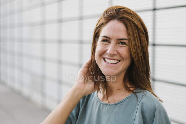 Lächelnde Frau blickt draußen in die Kamera — Stockfoto