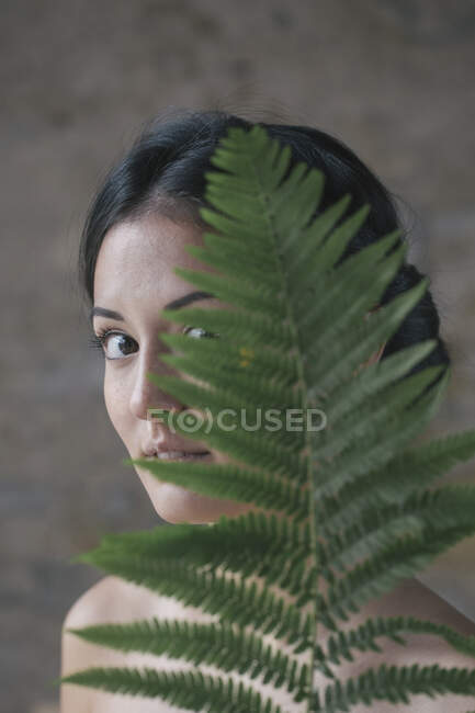Bella giovane donna che si nasconde dietro foglie di felce — Foto stock