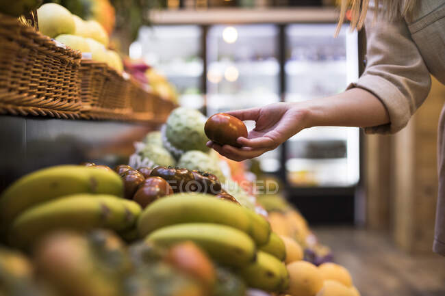 Imagen recortada de la mujer comprando tomates en la tienda de comestibles - foto de stock