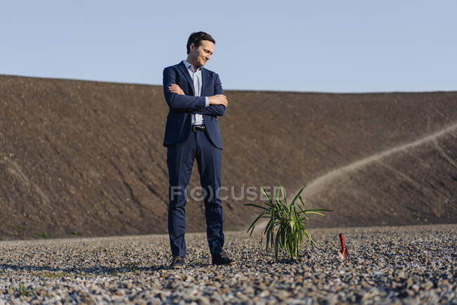 Homme d'affaires mature debout sur une pointe de mine désaffectée à côté d'une usine — Photo de stock