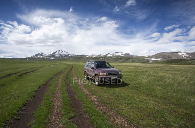 Georgia, Samtskhe-Javakheti, 4x4 car parked in grassy plateau — Stock Photo