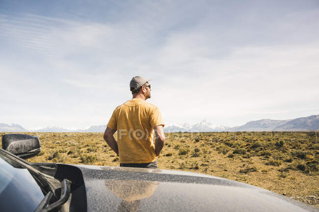 Rückansicht eines Mannes am Auto in einer abgelegenen Landschaft in Patagonien, Argentinien — Stockfoto