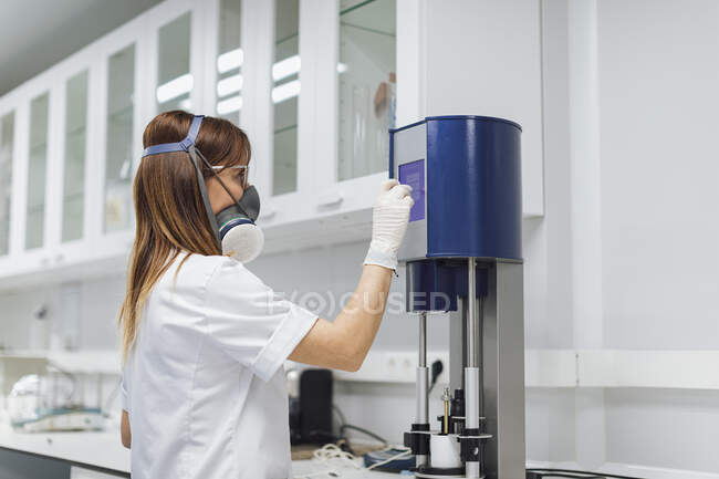 Confident female healthcare worker using medical equipment at laboratory — Stock Photo
