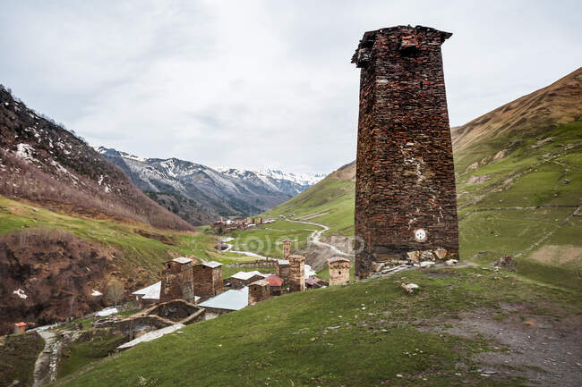 Geórgia, Svaneti, Ushguli, Torre de tijolo antigo com vista para a vila medieval de montanha — Fotografia de Stock