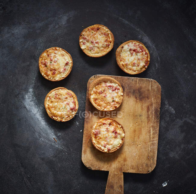 Спатула і міні піцца з сиром, помідорами і шинкою. — стокове фото