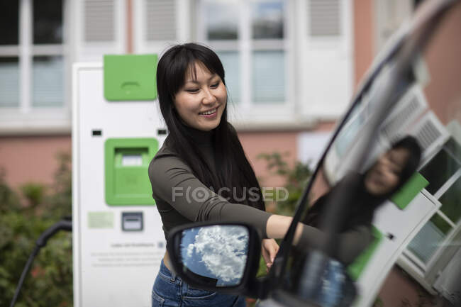 Carsharing, noleggio auto elettrica donna — Foto stock