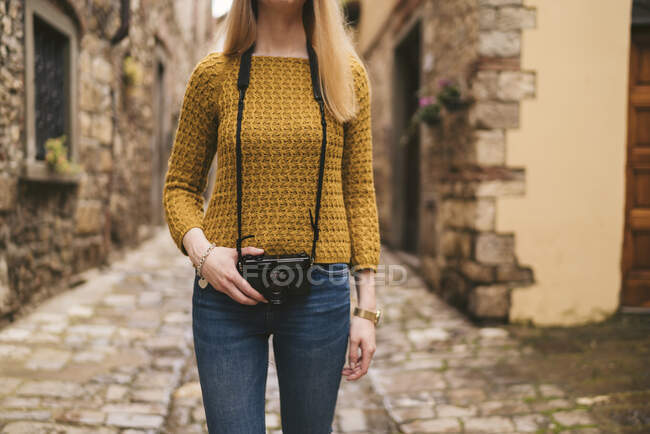Mid section of young woman with old-fashioned camera in old town, Greve in Chianti, Tuscany, Italy — Stock Photo