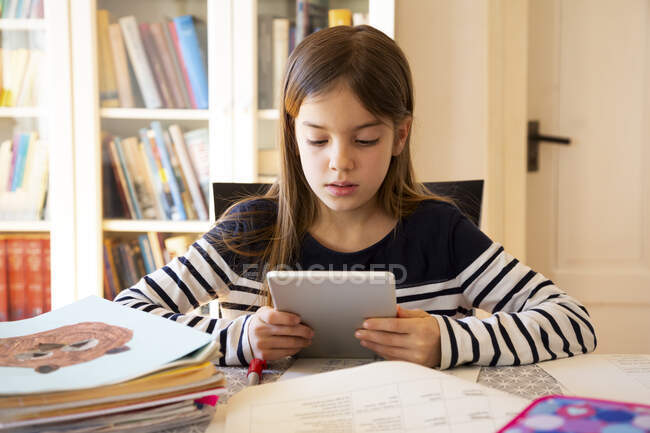 Mädchen macht Hausaufgaben mit digitalem Tablet — Stockfoto
