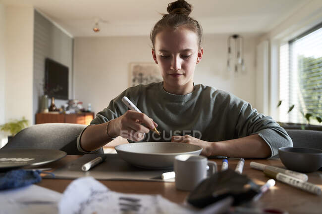 Девушка дома картина чаша с фарфоровой краской — стоковое фото