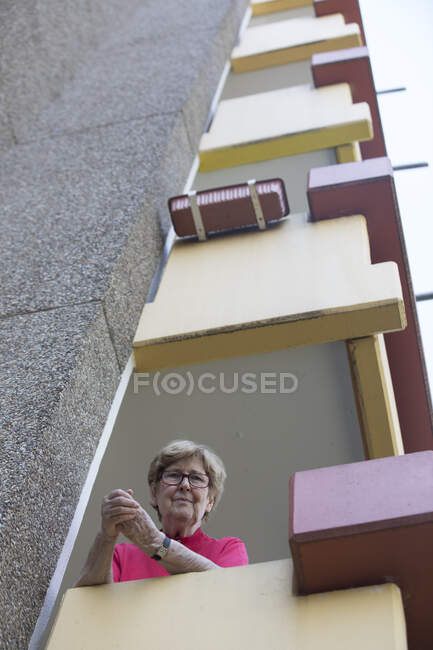 Старша жінка на балконі, дім на пенсії. — стокове фото