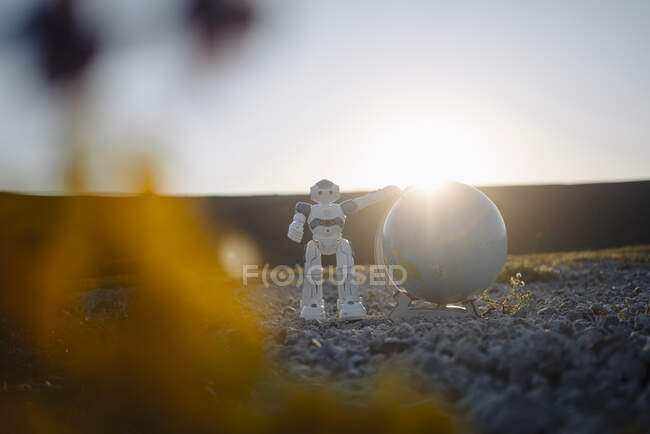 Mini robot con globo en una punta de mina en desuso al atardecer - foto de stock