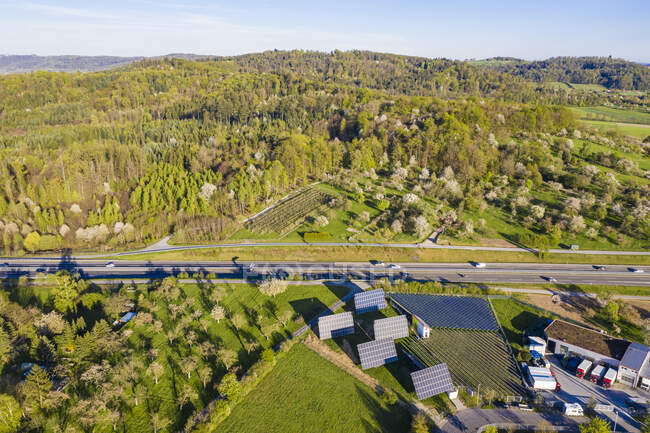 Германия, Феттемберг, Лехтбах, Вид с воздуха солнечной фермы Bundesstraat B14 на фоне зеленого леса — стоковое фото