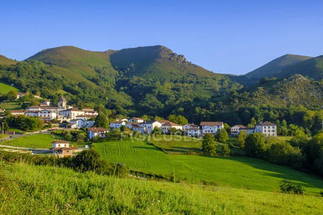 Іспанія, Наварра, Зугаррамурді, село біля підніжжя зелених лісистих пагорбів. — стокове фото