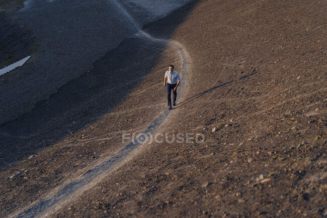 Homme d'affaires mature marchant sur une pointe de mine désaffectée — Photo de stock