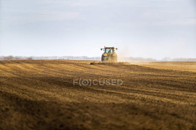 Landwirt mit Traktor pflügt Feld im Frühjahr — Stockfoto