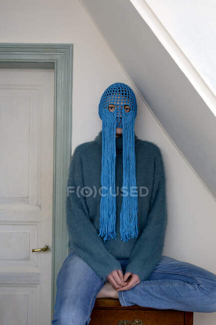 Portrait of young woman wearing crochetedblue headdress with fringes — Stock Photo