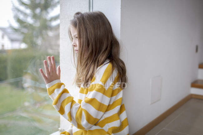 Mädchen zu Hause schaut aus dem Fenster — Stockfoto