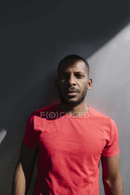 Portrait of sportsman at grey wall — Stock Photo