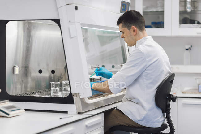 Científico joven y seguro que investiga en el laboratorio - foto de stock