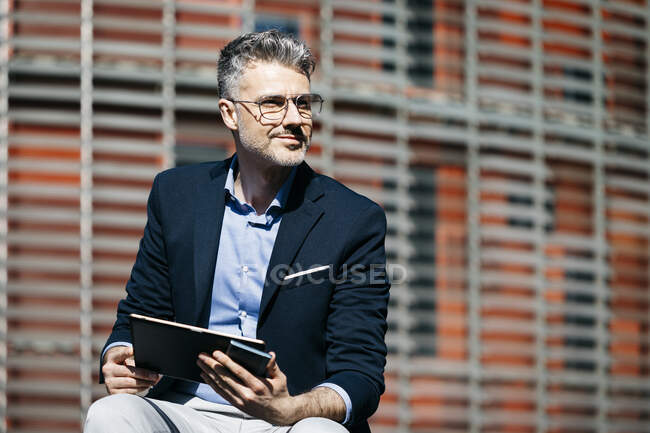 Uomo d'affari con tablet e cellulare in città — Foto stock