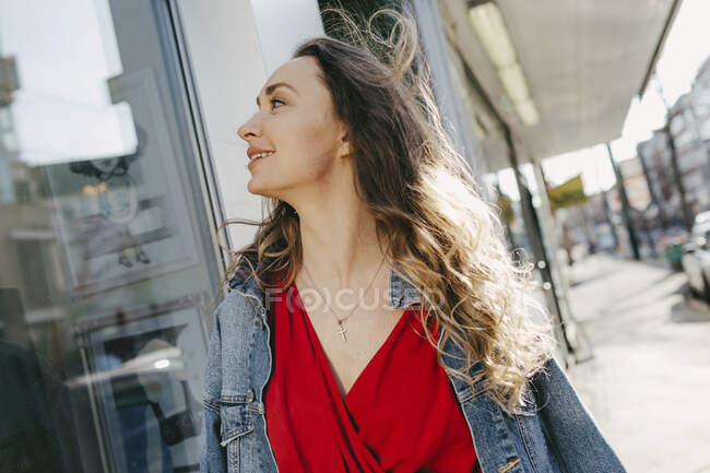 Woman looking in shop window in the city — Stock Photo