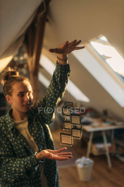 Junge Frau hält Design an Schnur zu Hause — Stockfoto