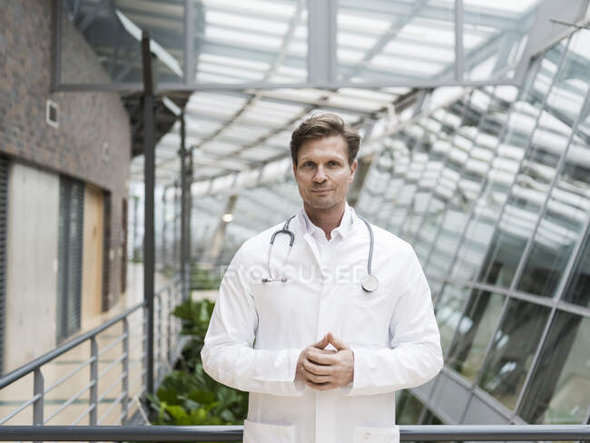 Portrait de médecin avec stéthoscope, debout dans l'atrium — Photo de stock