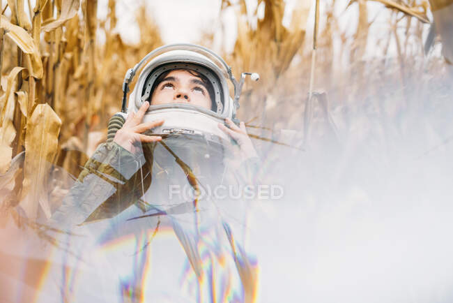 Jovem astronauta em pé no campo de milho murcho — Fotografia de Stock
