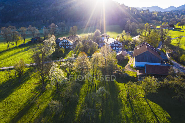 Deutschland, Bayern, Gaissach, Drohnen-Ansicht des Sonnenlichts beleuchtet ländliche Bauernhöfe — Stockfoto