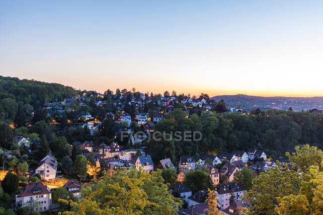 Alemania, Baden-Wurttemberg, Stuttgart, El cielo despejado sobre el distrito residencial arbolado al atardecer - foto de stock