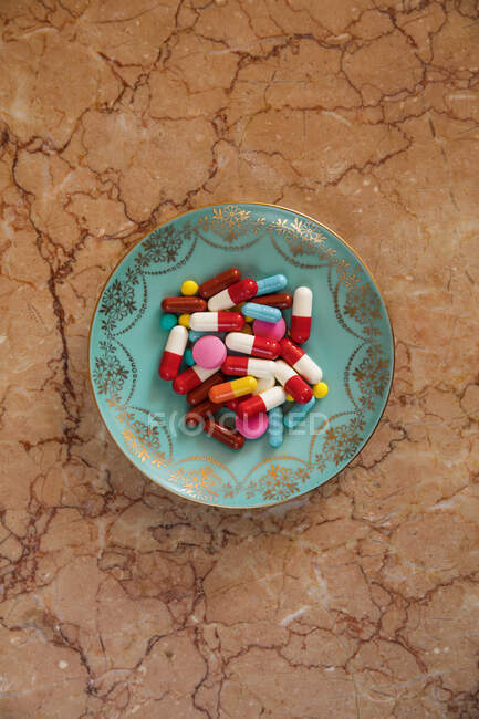 Assiette avec bouquet de diverses pilules et capsules — Photo de stock