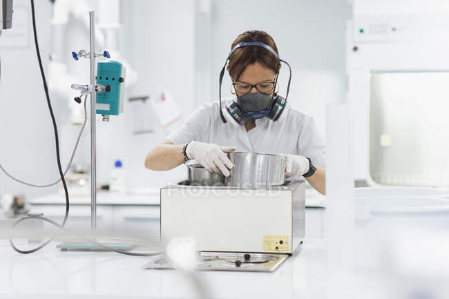Tecnico donna fiduciosa che fa ricerca durante l'utilizzo di attrezzature mediche in laboratorio — Foto stock