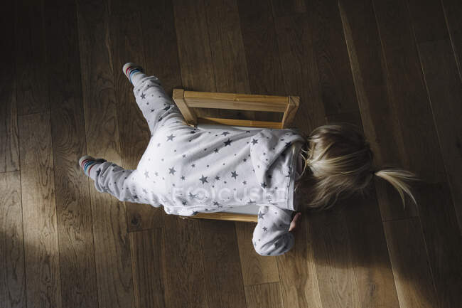 Rückenansicht des Kleinkindes auf Stuhl liegend, Ansicht von oben — Stockfoto