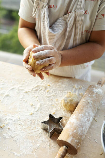 Crop view of boy kneading dough — Stock Photo