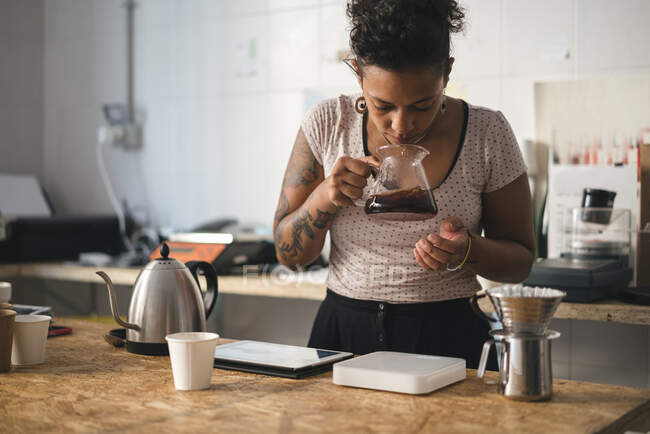 Donna che lavora in una torrefazione di caffè che odora di caffè — Foto stock