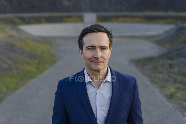 Portrait d'un homme d'affaires mature confiant sur une pointe de mine désaffectée — Photo de stock