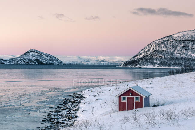 Прибрежный пейзаж с красной хижиной зимой, Лебедби, Фасе-Фьорд, Норвегия — стоковое фото