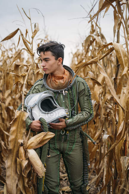 Jovem astronauta caminhando pelo campo de milho — Fotografia de Stock