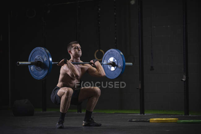 Man doing overhead squat exercise at gym — Stock Photo