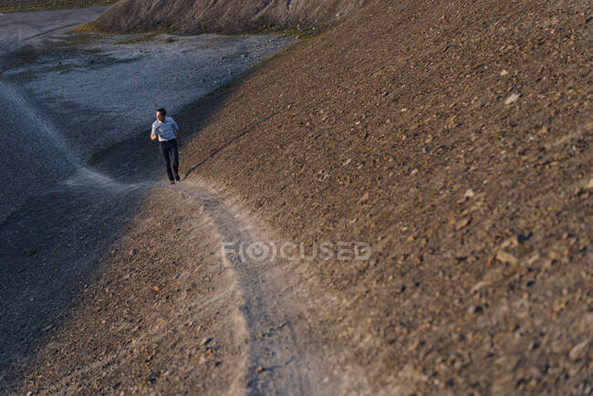 Mature businessman walking on a disused mine tip — Stock Photo