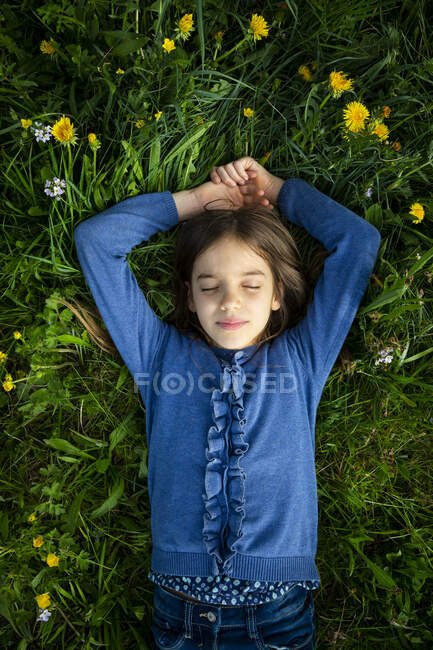 Portrait of girl with eyes closed relaxing on a meadow in spring — Stock Photo