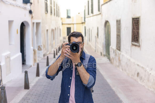 Hombre tomando fotos con cámara en la ciudad, Mao, Menorca, España - foto de stock